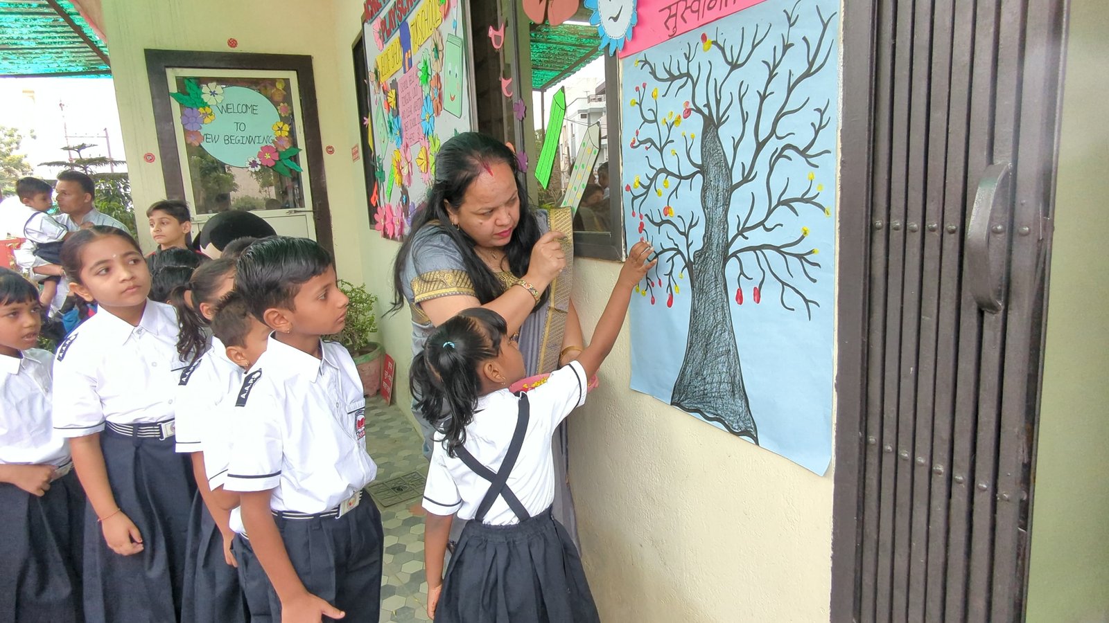 Fingerprint Tree Activity - Teacher guiding student to place paint fingerprints