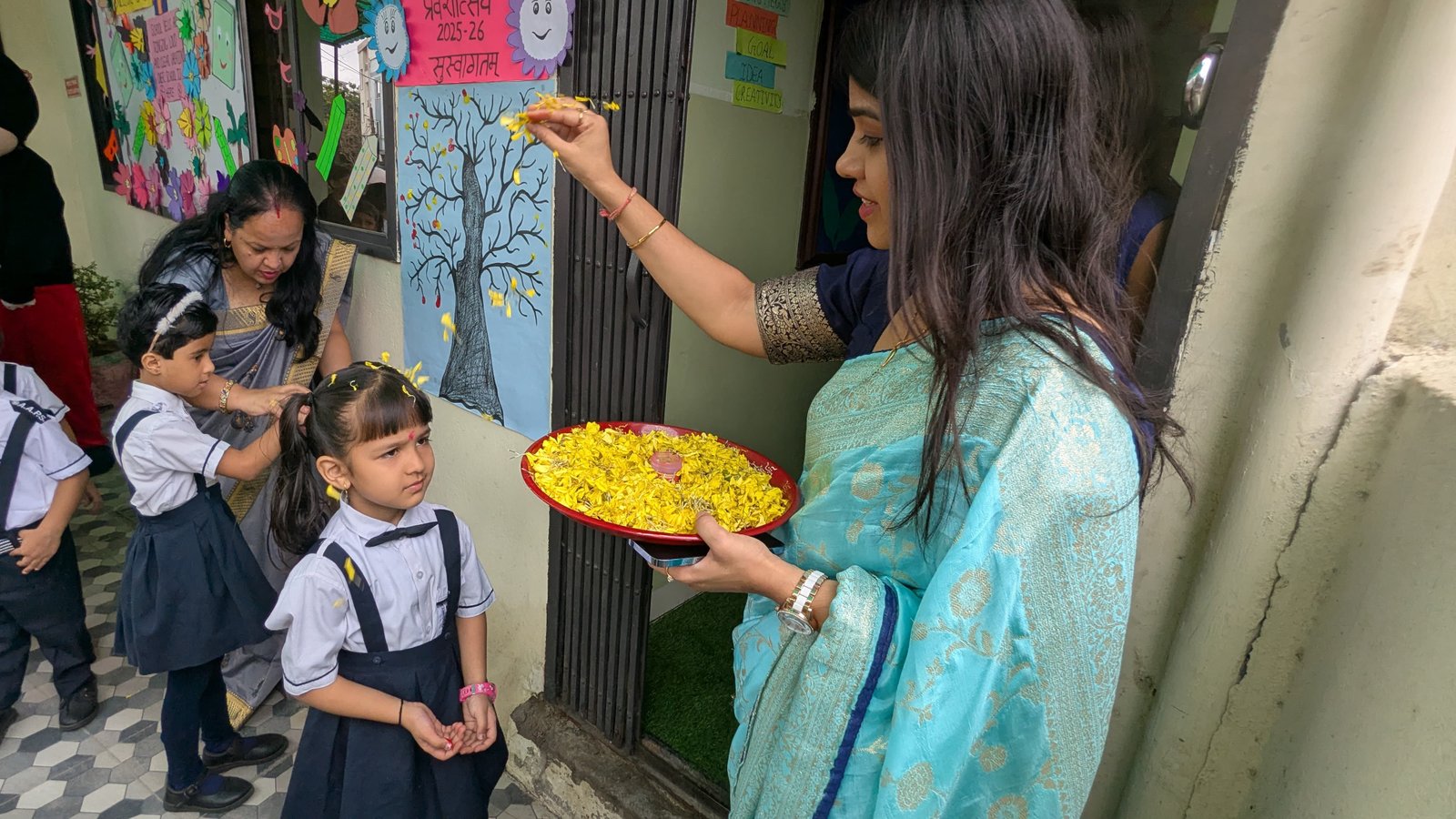 Welcome Ceremony - Teacher showering flower petals on a student for Praveshotsav
