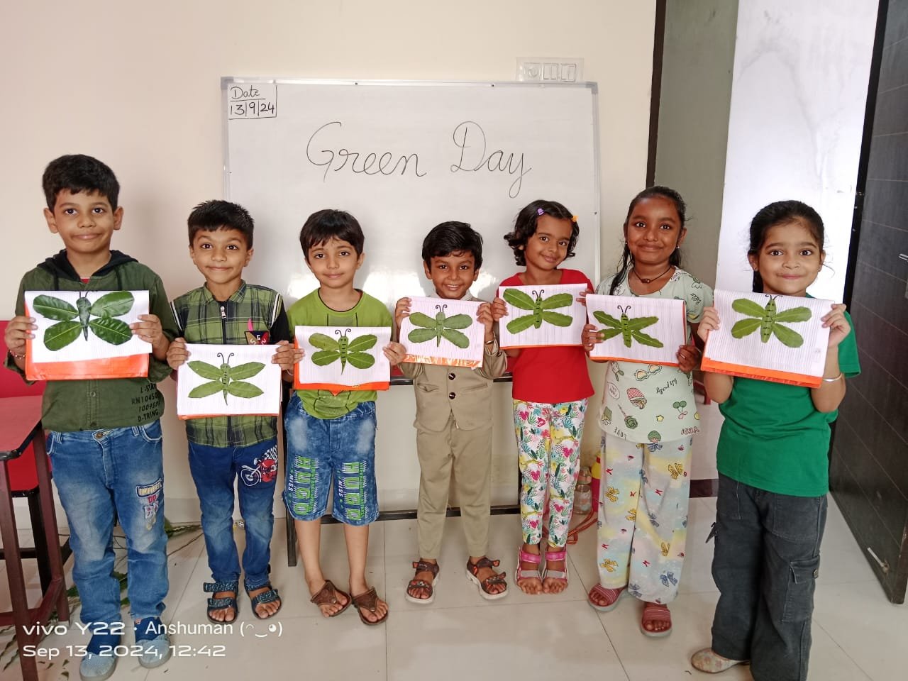 Green Day Leaf Craft - Students displaying dragonfly leaf art